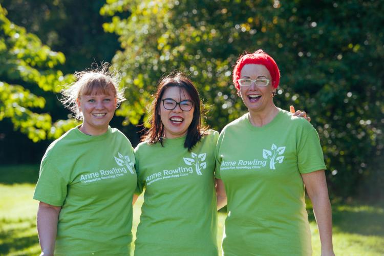 3 supporters smiling at the camera wearing green Anne Rowling Clinic T-shirts