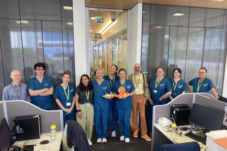The MS research team celebrating the 40th participant to be randomised to the Octopus clinical trial. One of the team members is holding a plush toy orange Octopus.