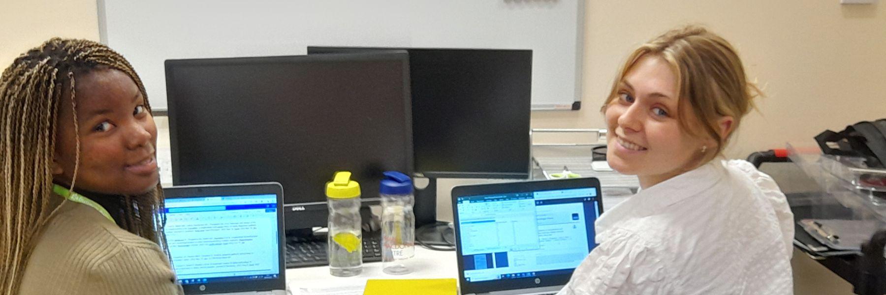 Two University of Edinubrgh Employ.Ed Interns sitting at their laptops