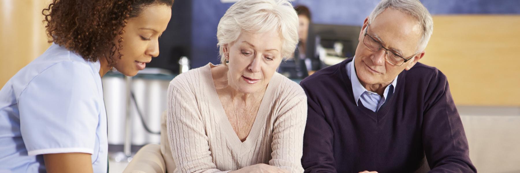 Nurse talking to older couple