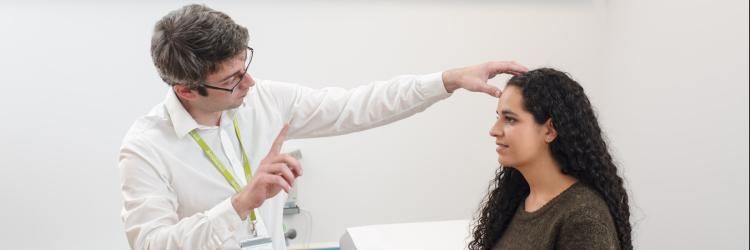A doctor performs a neurological eye exam on a research participant