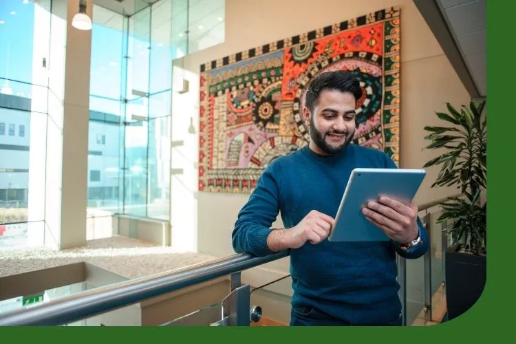 A picture of a person reading the winter 2025 newsletter on an iPad