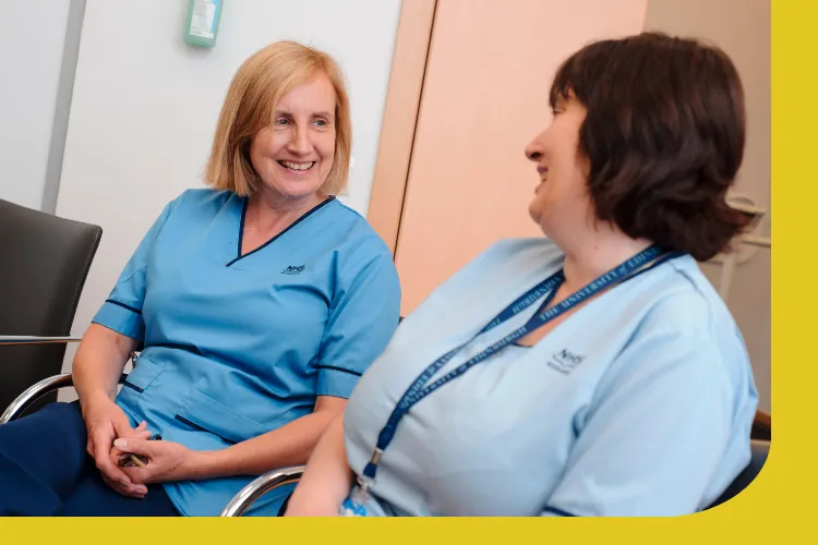 A picture of a neurology specialist nurse and healthcare support worker in a clinical setting.